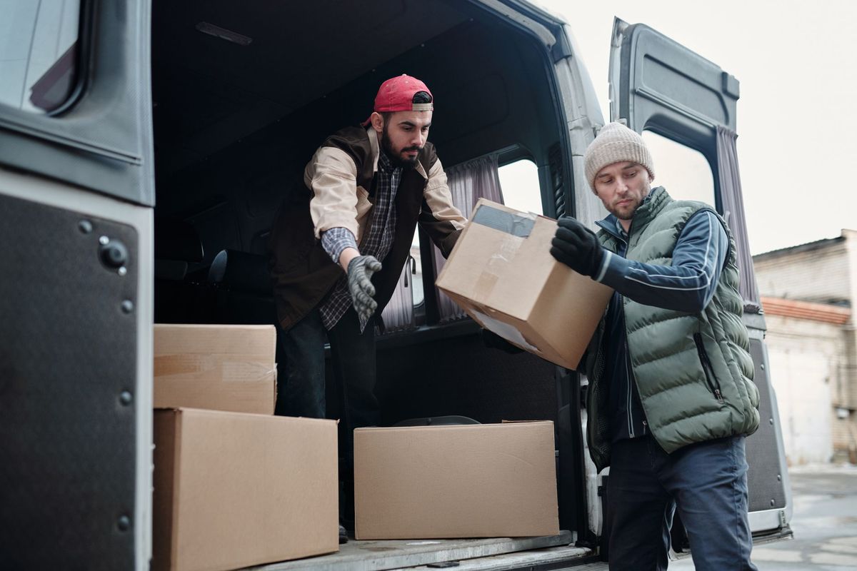 Professional movers carefully loading boxes into a moving truck