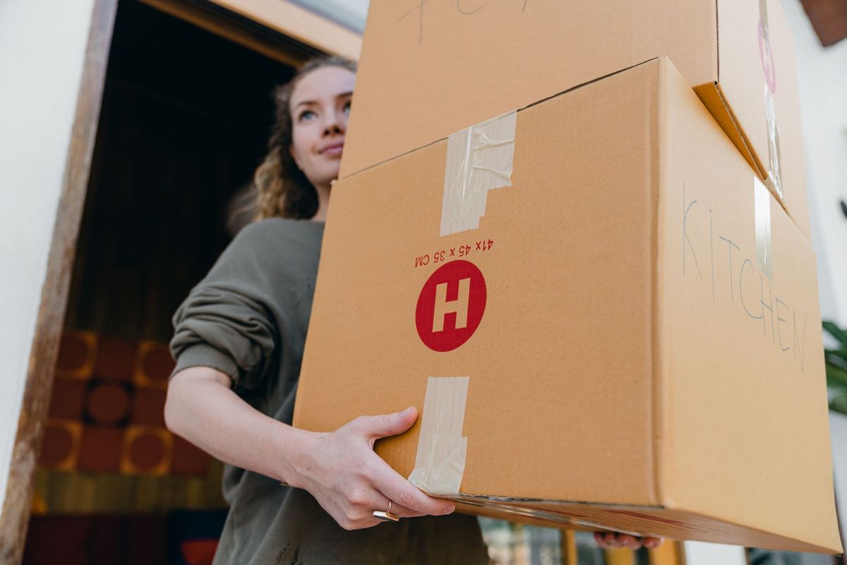 Professional movers carrying boxes into a North Stamford home