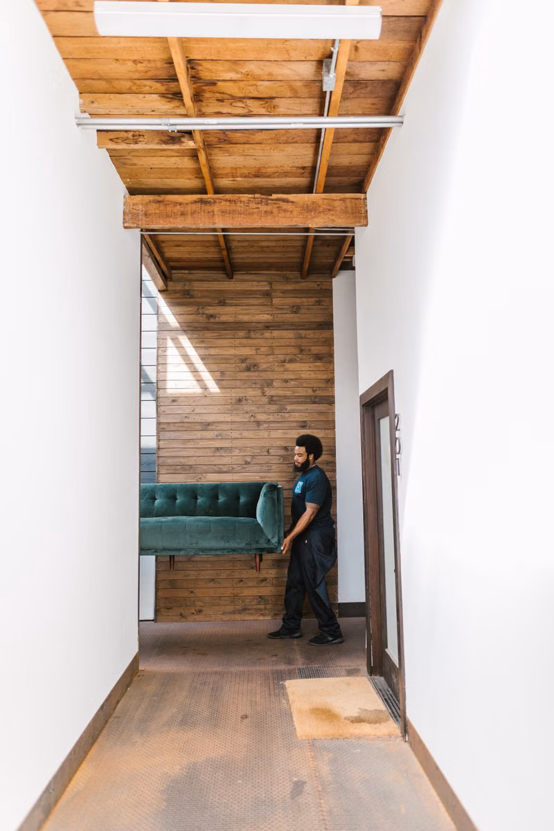 Mover carefully guiding a piano through a doorway